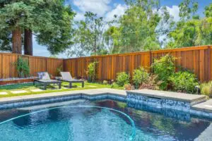 A pool with a wooden fence and some chairs