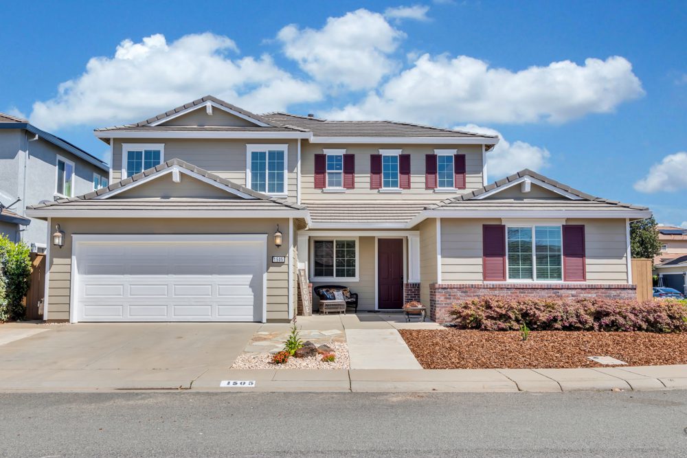 A house with a garage and driveway in front of it.