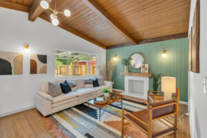 A living room with a couch, chair and fireplace.