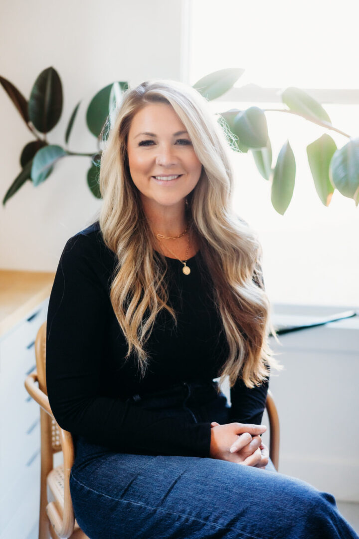 A woman sitting in a chair with long blonde hair.