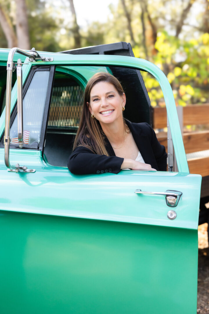 A woman sitting in the drivers seat of a truck.